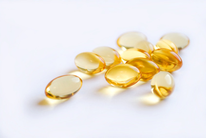 closeup of golden translucent capsules in front of white background